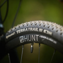 Load image into Gallery viewer, Close-up of a Hunt Terra Trail bicycle tire with tread pattern and branding.
